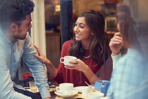 A group of friends enjoying coffee while chatting at a cafe.